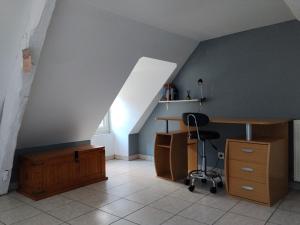 an attic room with a desk and a chair at Yapas in Beaumont-sur-Sarthe