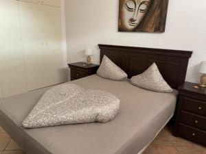 a bed with a headboard and pillows on it at Apartmán Centrum in Los Cristianos