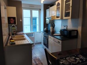a small kitchen with a sink and a microwave at Yapas in Beaumont-sur-Sarthe