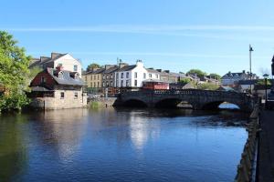 a bridge over a river in a town with buildings at Modern house Boyle in Boyle