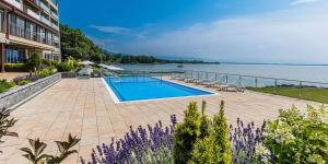 a swimming pool next to a large body of water at Hotel Glamour in Kaluža