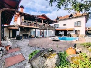 a large house with a swimming pool in the yard at Къща за гости Бащин дом in Apriltsi