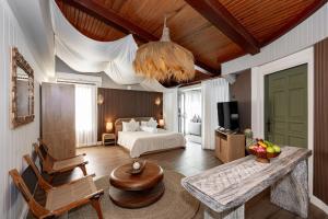 a hotel room with a bed and a table and chairs at The Taksim Royal Beachfront Resort in Patong Beach