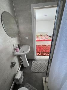 a bathroom with a sink and a mirror and a bed at Center guesthouse in Kochkorka