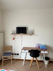 a room with a desk and a tv on a wall at Bed &... Fly in Grassobbio