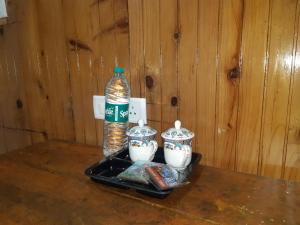 a bottle of water and two tea cups on a tray at Himalayan Heritage Stay in Darjeeling