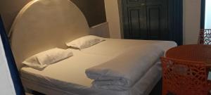 a bedroom with a white bed with pillows and a table at Green forest BnB and cafe in Manāli