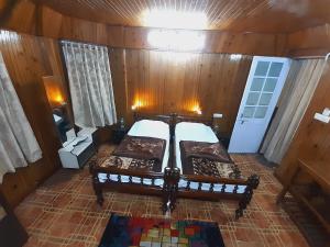 a bedroom with two beds in a wooden cabin at Himalayan Heritage Stay in Darjeeling +16 photos
