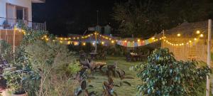 a garden with a string of lights and tables and chairs at Pennylane Hotel - Aesthetic Rooms with pottery studio, artshala, garden cafe, free airport pickup for 7 or more nights bookings in Rishīkesh +66 photos