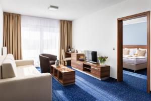 a hotel room with a couch and a television at Kurhotel Pyramide Sibyllenbad in Neualbenreuth