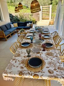 a long table with plates and glasses on it at Villa Depiros Corfu in Lefkimmi