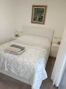 a white bed in a bedroom with a picture on the wall at Suite Poblamar in Pobla de Montornés