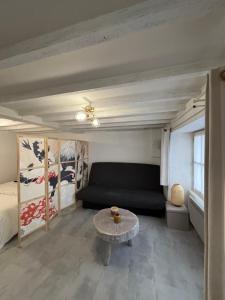 a bedroom with a couch and a table in a room at Toue de Loire in Chaumont-sur-Loire