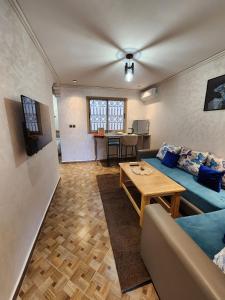 a living room with a blue couch and a table at Residence Imlil Ouarzazate in Ouarzazate