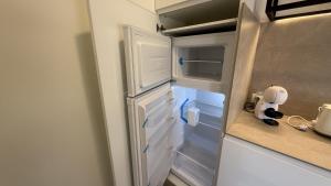 a refrigerator with its door open in a kitchen at Bormujos Suites Sevilla in Bormujos