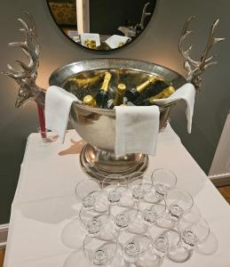 a table with wine glasses and a bucket of wine bottles at The White House Hotel in Williton