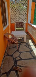 a patio with a bench and a table and a skateboard at Orange apartments 3 in Watamu