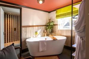 a bath tub in a bathroom with an orange ceiling at The Crown Hotel in Lynton +57 photos