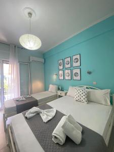 two beds in a room with blue walls at Villa Loukia in Corfu