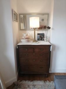 a dresser with a mirror and a lamp on it at Large Sunny King-Size En-Suite in Hastings