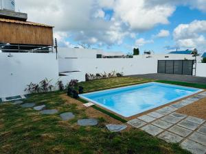 a swimming pool in the backyard of a house at Villa Le Caprice in Grand-Baie
