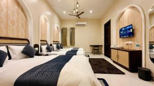 a row of beds in a hotel room at Hotel Omkareshwar Jyotirling Inn in Godarpura +103 photos