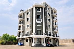 a tall building with motorcycles parked in front of it at Hotel Omkareshwar Jyotirling Inn in Godarpura