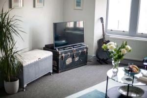a living room with a television and a guitar at Verity and Ilfracombe Harbour View in Barnstaple