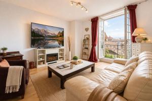 a living room with a couch and a table at La Salamandre - Un écrin médiéval pour vos souvenirs - Imaginez-vous, réveillé par le murmure de Sarlat, dans un appartement spacieux et chaleureux, au cœur de la Cité classée - 2 chambres - Une magie à vivre sans modération - Réservez dès maintenant ! in Sarlat-la-Canéda