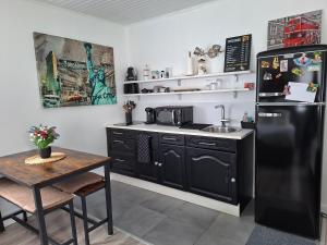 a kitchen with a black refrigerator and a table at casa de invitados estilo normandie in Chamblac