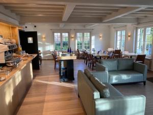 ein Restaurant mit Sofas, Tischen und einer Bar in der Unterkunft Hotel Amary in Maldegem