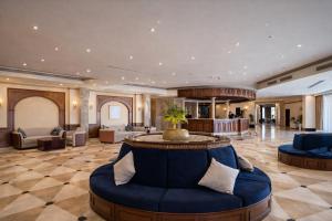 a lobby of a hotel with a blue couch at Grand Tibarose Hotel in Cairo