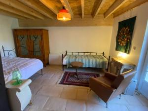 a bedroom with a bed and a couch and a chair at Moulin sous la Vergne in Nanteuil-en-Vallée