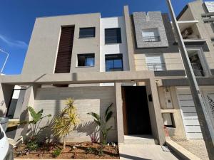 a modern house with a building with a door at Résidence Jasmin in Harqalah