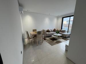 a living room with a couch and a table at Résidence Jasmin in Harqalah