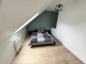 a bedroom with a bed in a attic at La nouvelle école in Ruillé-en-Champagne