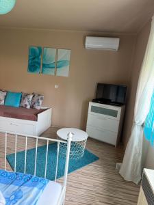 a small room with a bed and a tv at Zso-Zé Apartman in Tiszafüred