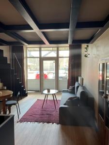 a living room with a couch and a table at G Loft - Spacious Urban Apartment with Bathtub and Private Entrance in Kaunas