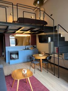 a living room with a loft bed and a table and chairs at G Loft - Spacious Urban Apartment with Bathtub and Private Entrance in Kaunas