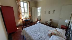 a bedroom with a bed and a desk and a window at Cascina Barosca in Castelnuovo Don Bosco