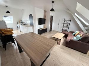 a living room with a couch and a table at La nouvelle école in Ruillé-en-Champagne