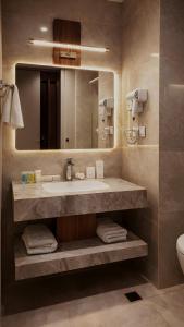 a bathroom with a sink and a mirror at View Lounge Hotel in As Sulaymānīyah