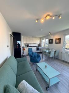 a living room with a green couch and a table at Duhner Leuchturm, Ferienwohnung DL02 in Cuxhaven