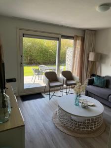 a living room with a couch and a table at Appartement Noflik, Amelander Kaap in Hollum
