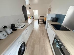 a kitchen with a washer and dryer on a counter at La nouvelle école in Ruillé-en-Champagne +5 photos