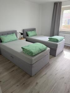 two twin beds in a room with wood floors at Ruheblick Apartment Essen in Essen