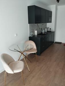 a kitchen with a glass table and two chairs at Amazing Studio Close to Oldtown in Gdańsk