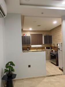 a kitchen with a white wall and a counter top at Talya Apartment in Mecca