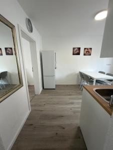 a kitchen with a white refrigerator and a table at Ruheblick Apartment Essen in Essen