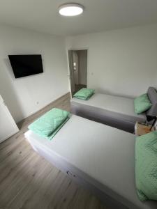 a room with two beds and a flat screen tv at Ruheblick Apartment Essen in Essen